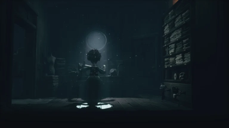 Capture d'écran du contenu additionnel de Little Nightmares III : The Backstage. Une couturière est à l'oeuvre, de dos, dans une pièce très sombre où seul une légère lumière provient d'une petite fenêtre, mettant en valeur la femme en plein travail.