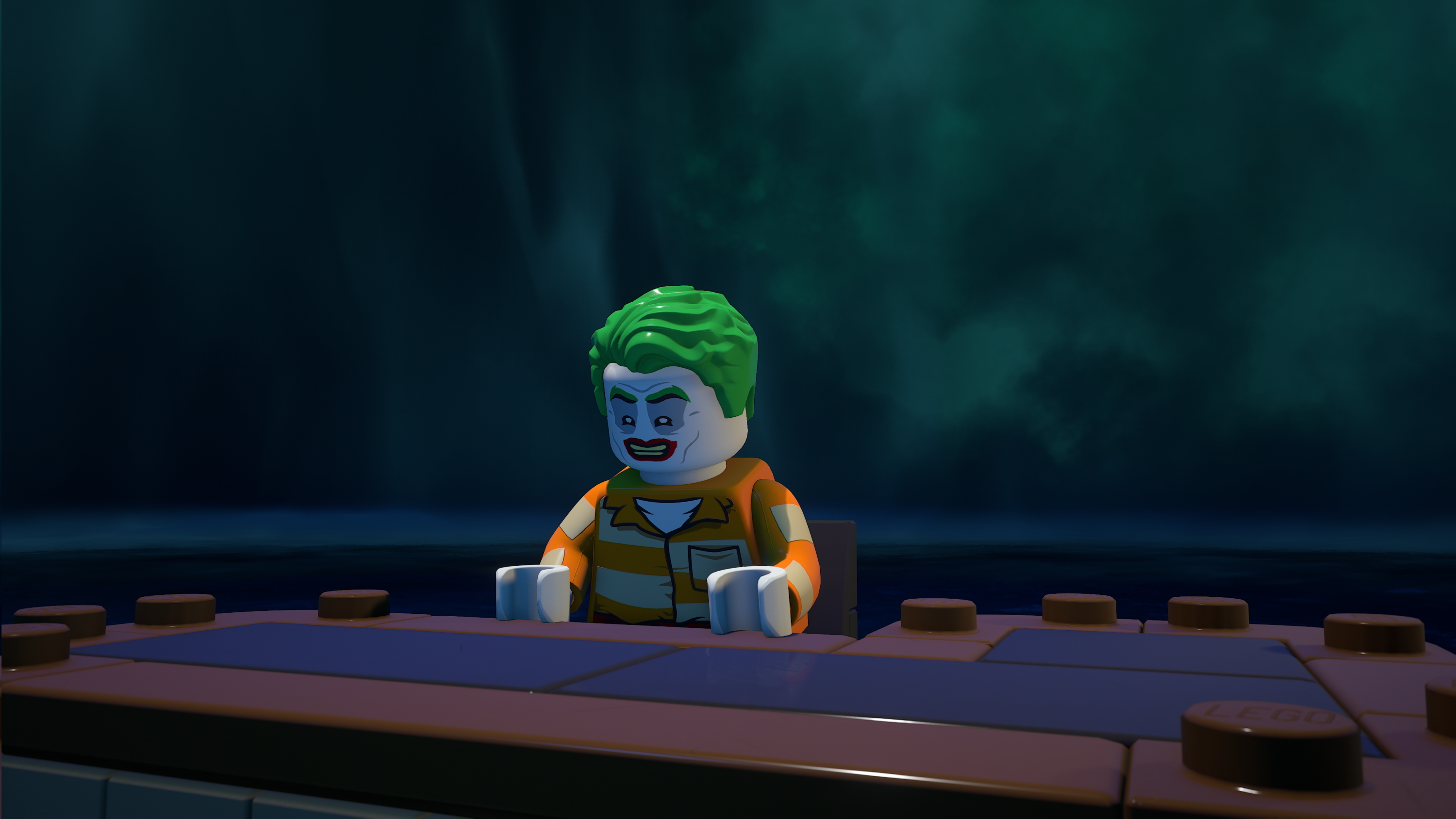 LEGO Batman : un nouveau DLC répand le chaos à Gotham 3 Image du jeu LEGO Batman : L'Héritage du Chevalier Noir. Le Joker est assis à un bureau, en tenue de prisonnier. Il est en train de rire.